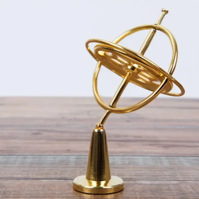 Orbitrix gyroscope in gold finish on its display stand