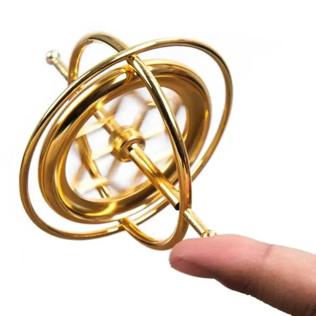 Orbitrix gold gyroscope balanced and spinning on a fingertip