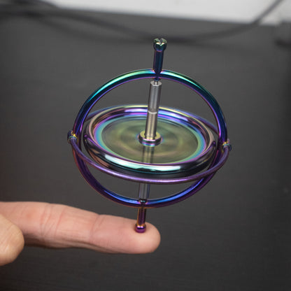 Orbitrix rainbow gyroscope spinning on a fingertip